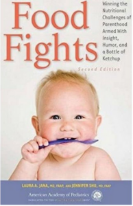 An blonde-haired baby faces the camera chewing on the handle of a purple spoon on the cover of a book entitled "Food Fights."